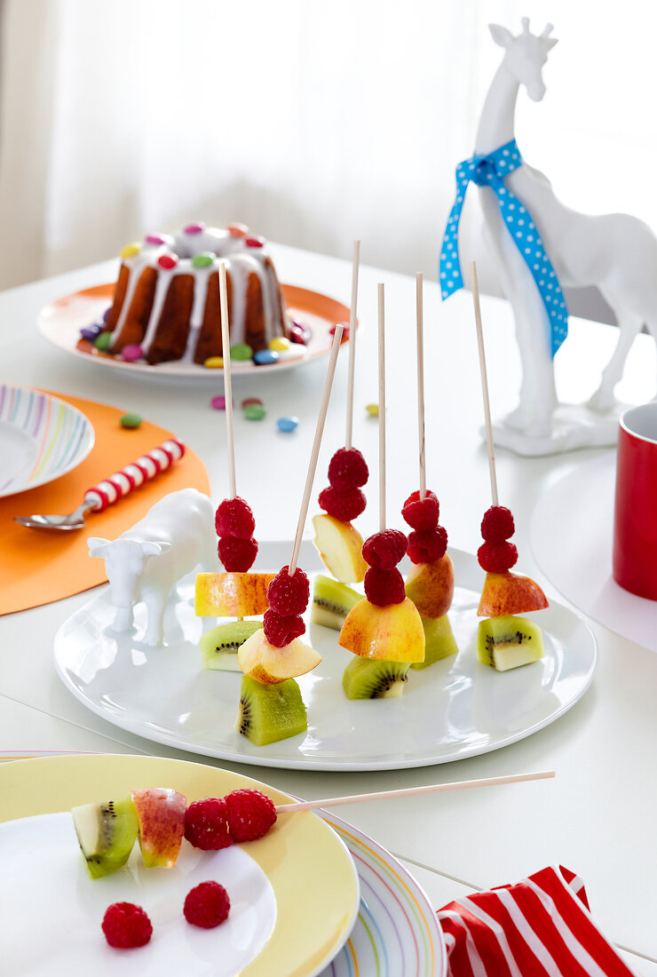 Obstspieße auf Teller, Tisch gedeckt für Kindergeburtstag