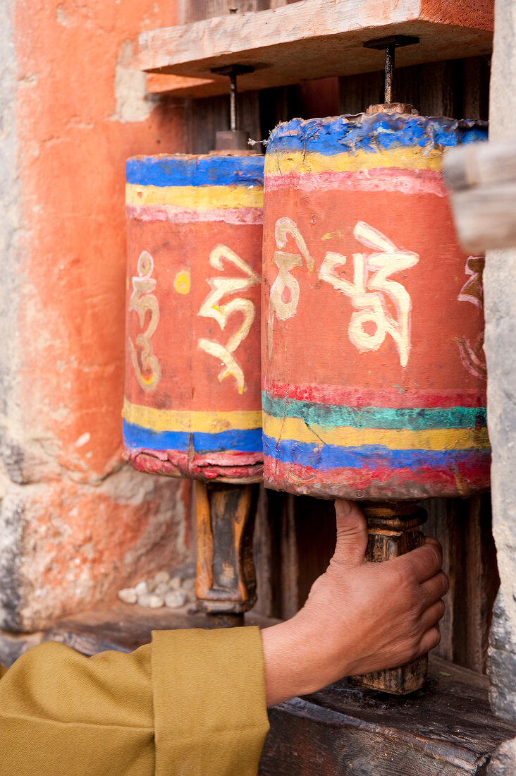 Hand holding prayer wheels at Jampey Lhakhang temple, Bhutan