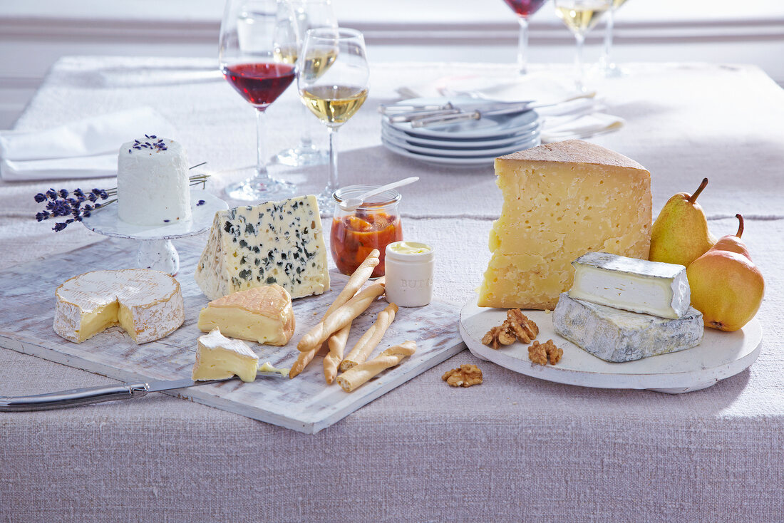 Variety of cheese on trays and glasses of red and white wine