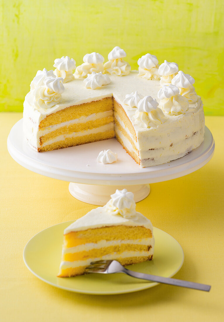 Gluten free lemon cake on cake stand with slice of it on plate