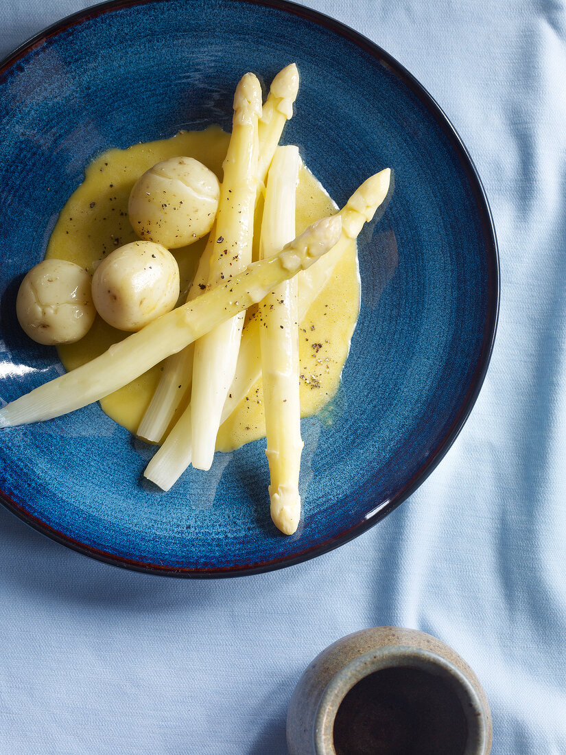 Close-up of asparagus with potatoes and hollandaise sauce on plate