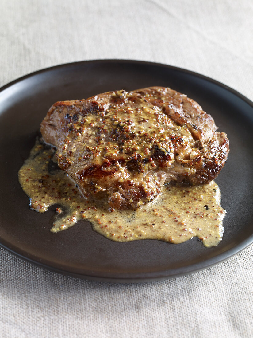 Close-up of veal escalope with mustard sauce on plate