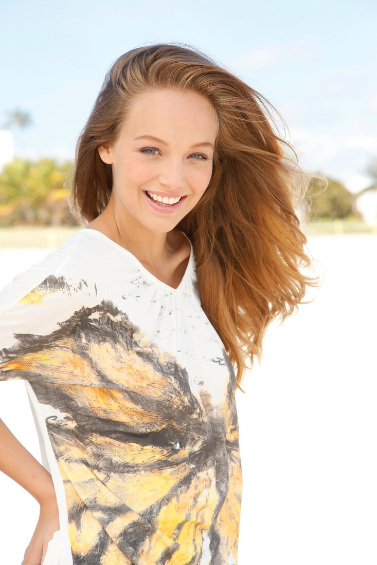 Portrait of beautiful woman wearing white patterned top, smiling