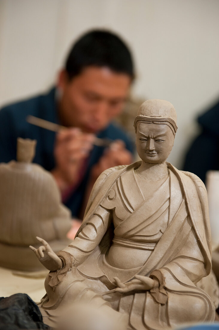 Man concentrating while drawing on clay at art school, Thimpu, Bhutan