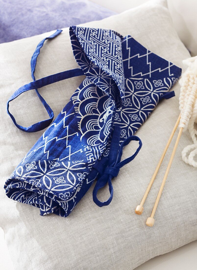 Knitting and crochet needles in blue and white fabric needle case