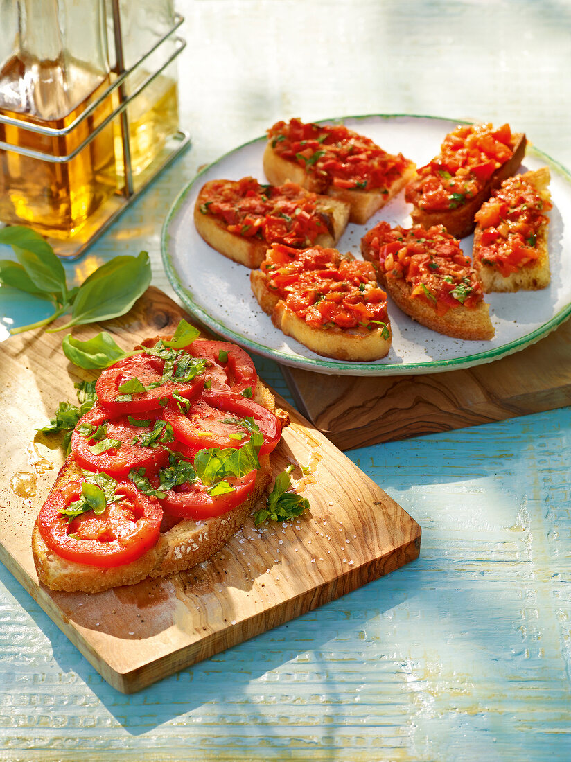 Bruschetta with tomato on plate and wooden board
