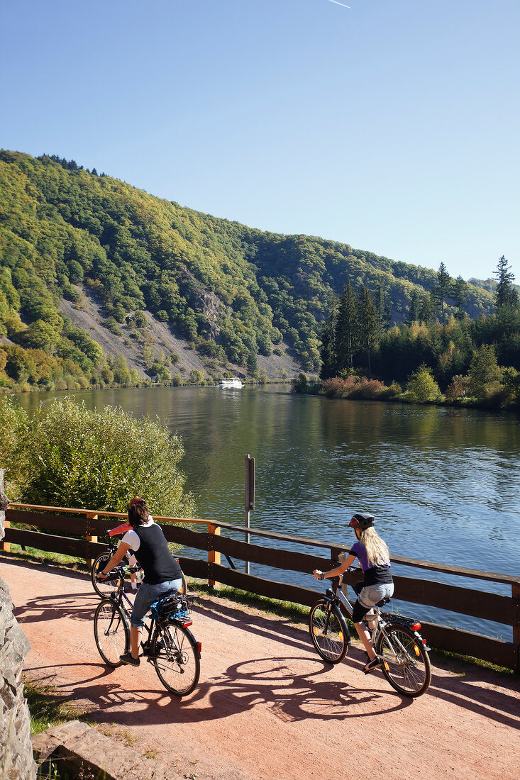 People cycling beside Saar loop in Mettlach, Saarland, Germany