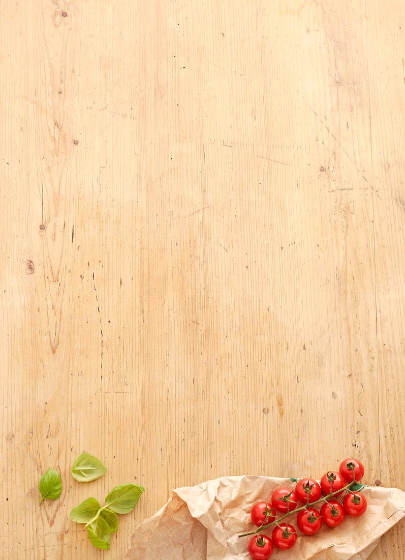 Fresh basil and vine tomatoes on a wooden surface