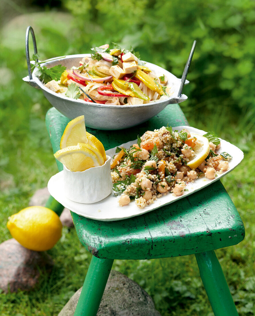 Glass noodle salad with tofu in bowl and couscous salad with chickpeas in serving dish