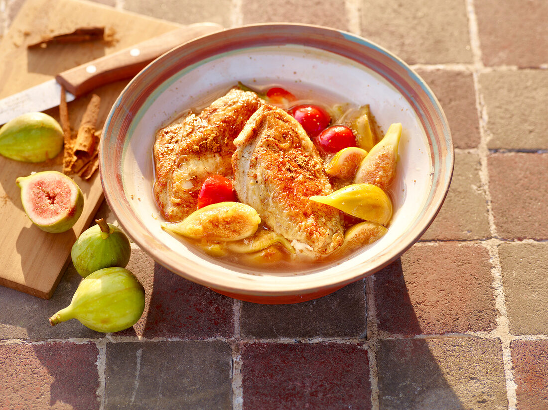 Fig with chicken in bowl beside figs on cutting board