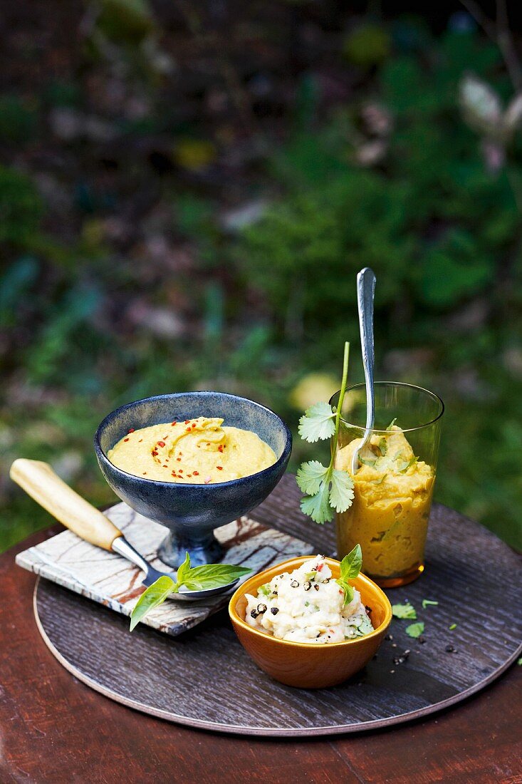 Hummus, a dip with red lentils, and a white bean dip