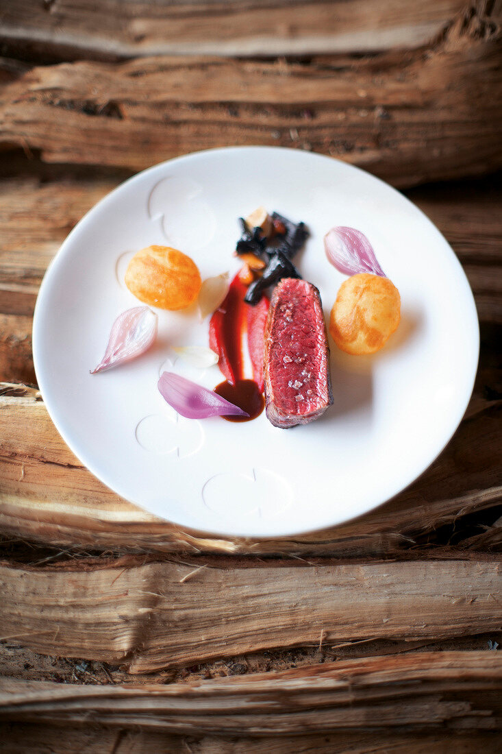 Saddle of venison with carrots and beetroot puree on plate
