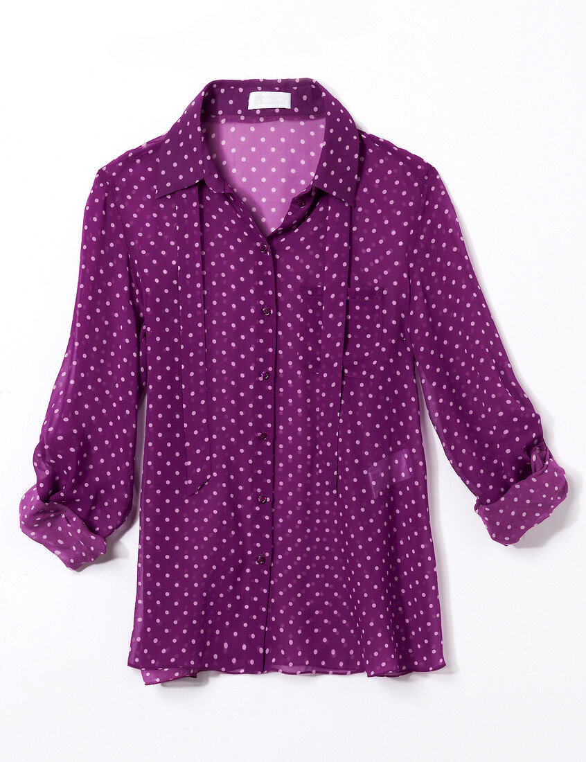 Close-up of purple polka dot shirt blouse on white background
