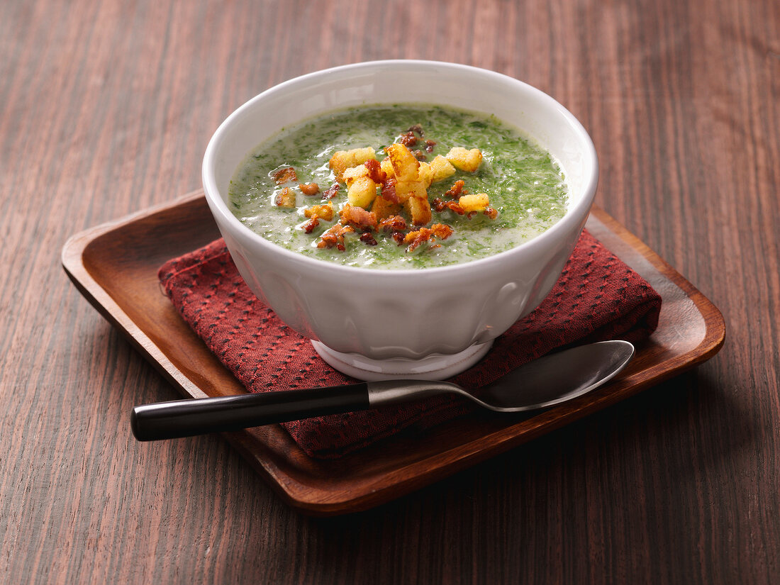 Bowl of lettuce soup with bacon croutons