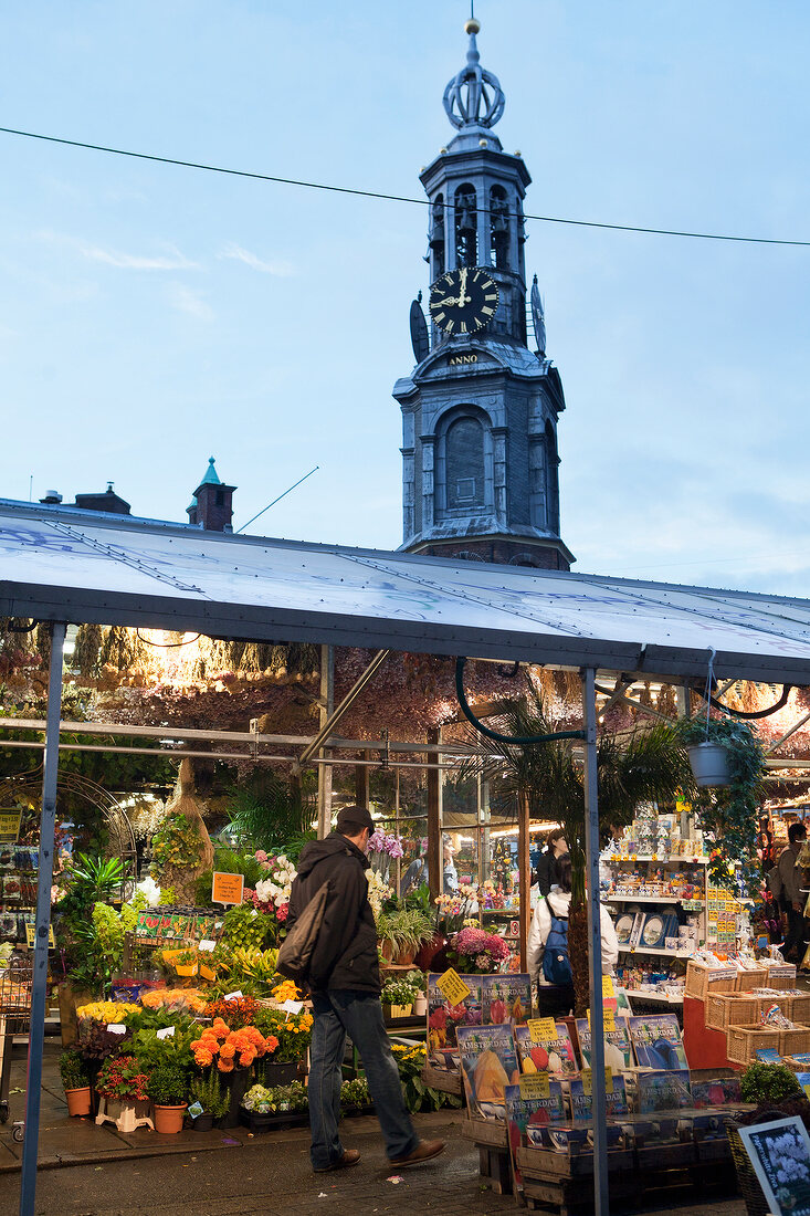 Man walking in flower market in front of Mint Tower, Singel, Amsterdam, Netherlands