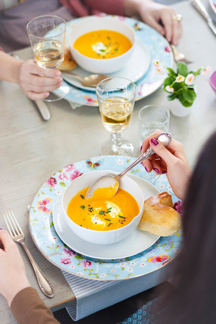 Two women having cream of carrot soup with rabbit made of pizza dough
