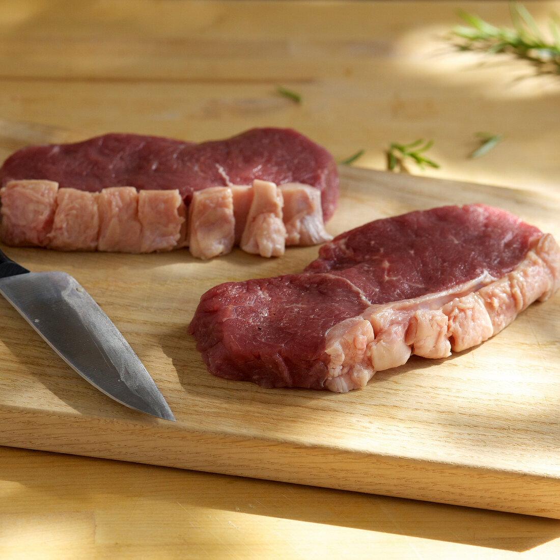 Close-up of steaks on wooden board, step 2