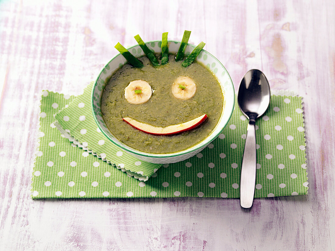 Bowl of green soup decorated for children