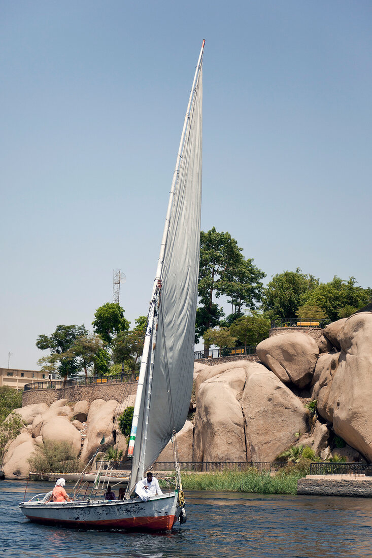 View of people in sailboats against rocks of Elephantine, Egypt