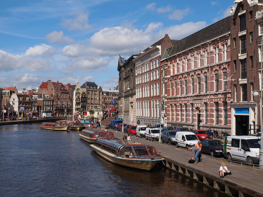 View of canal houses and ferryboats in canal Amsterdam at Nieuwmarkt, Netherlands