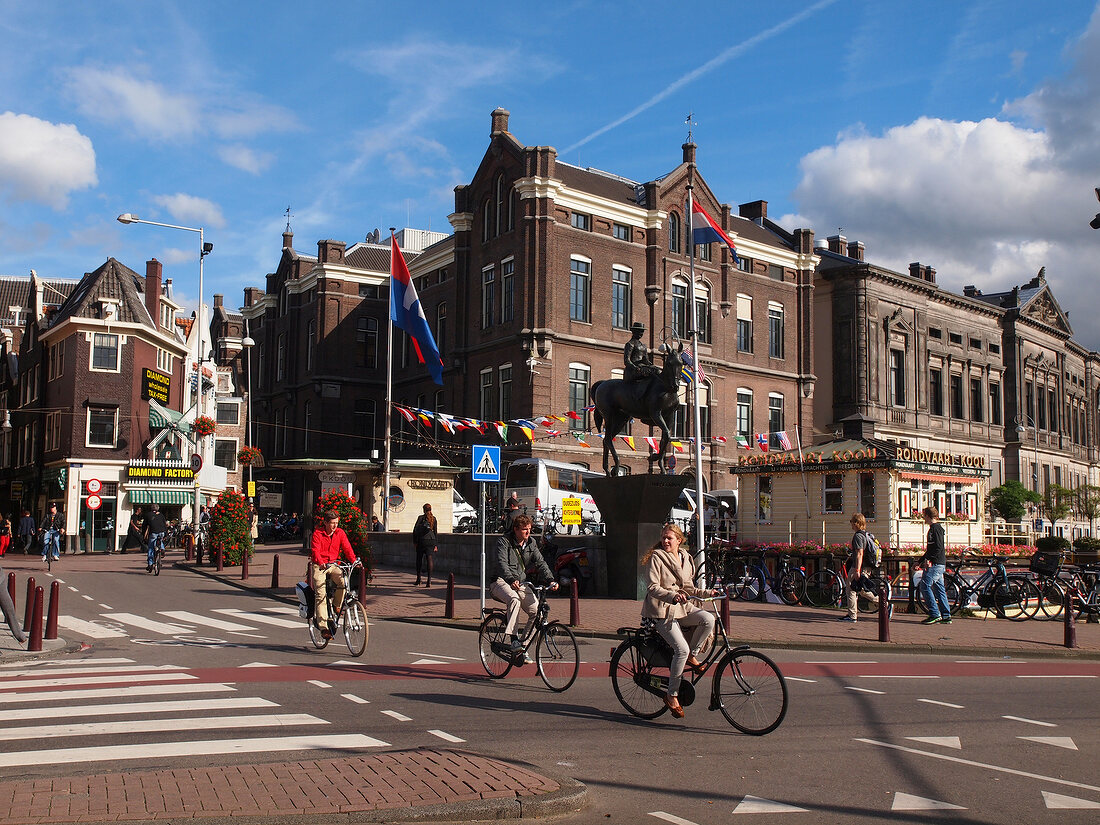 View of cyclists on street and Equestrian statue in Rokin Amsterdam, Netherlands