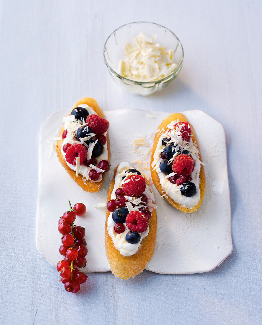 Three crostinis with curd and berries on plate