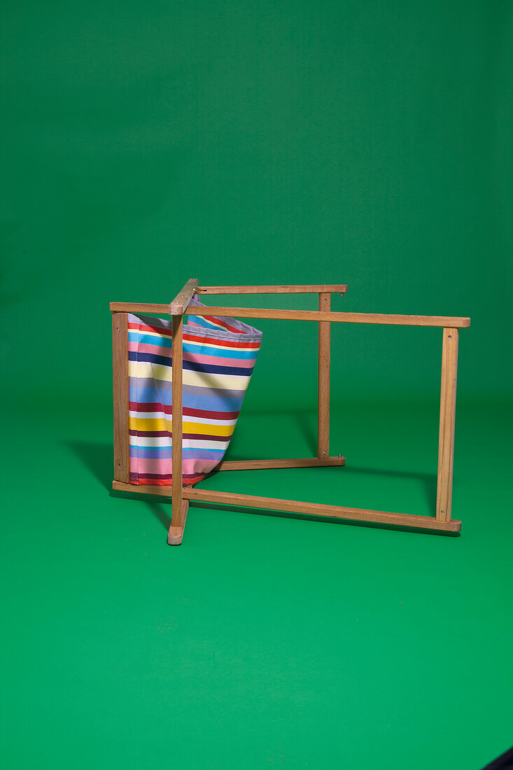 Folding deck chair with stripes pattern on green background