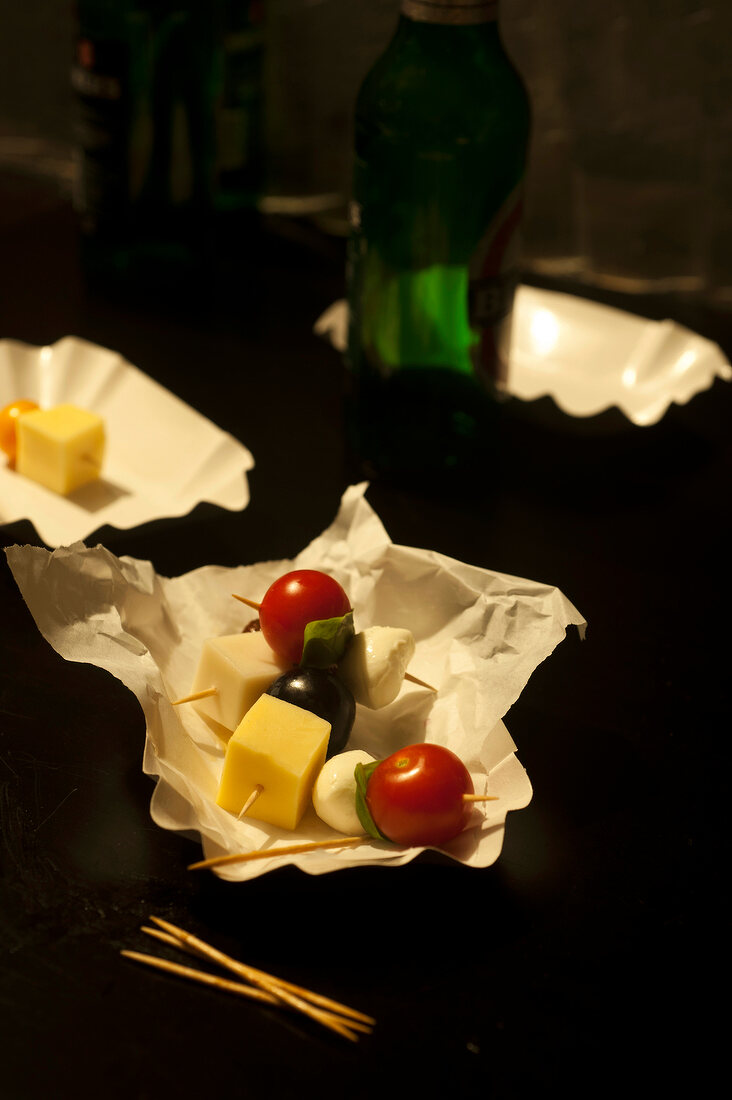 Cheese cubes with tomatoes, olives and herbs in skewers