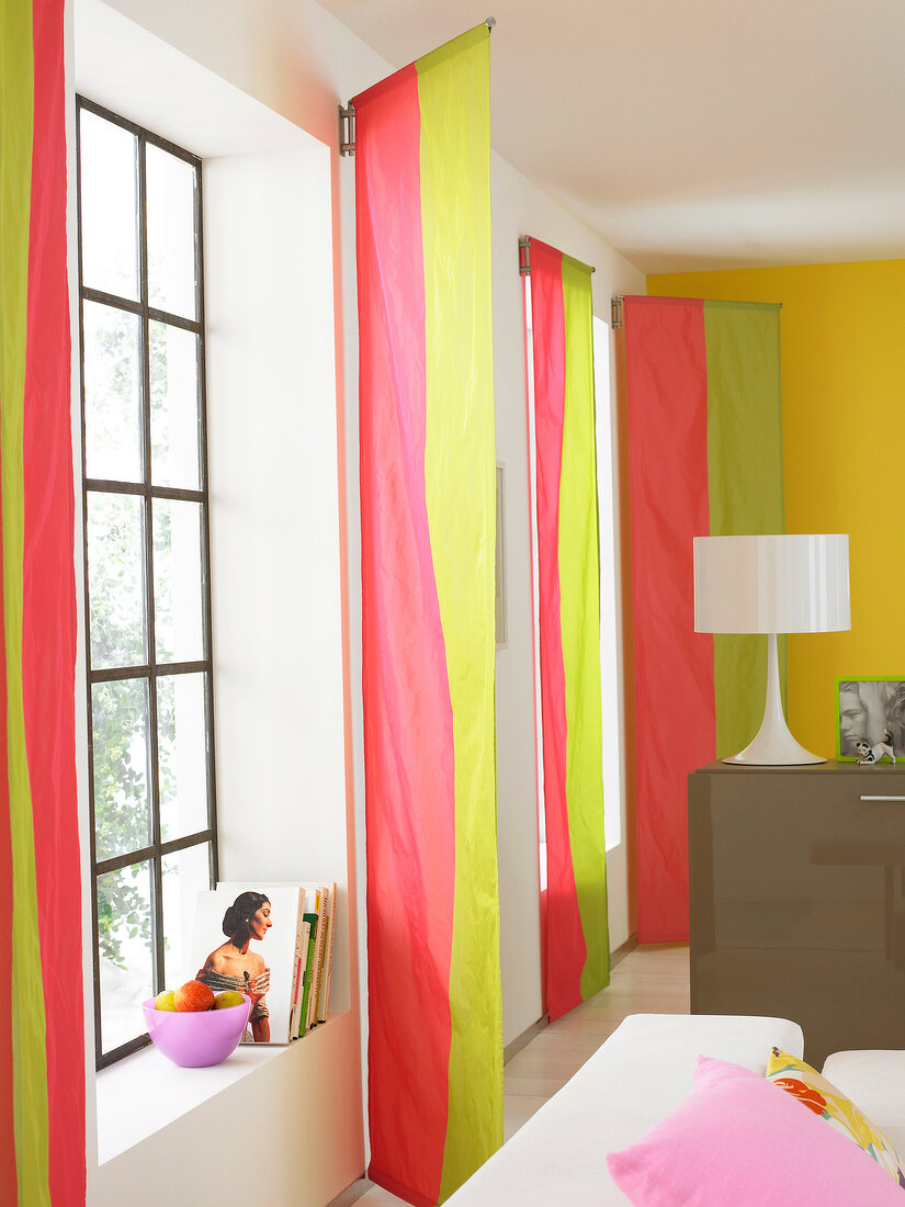 Buntes Wohnzimmer mit gestreiften Vorhängen in rot gelb