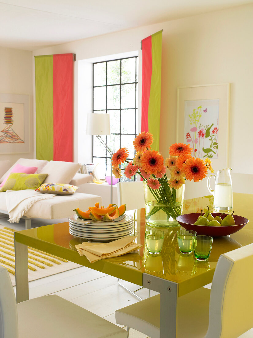 Colourful dining table by window and flowers on table