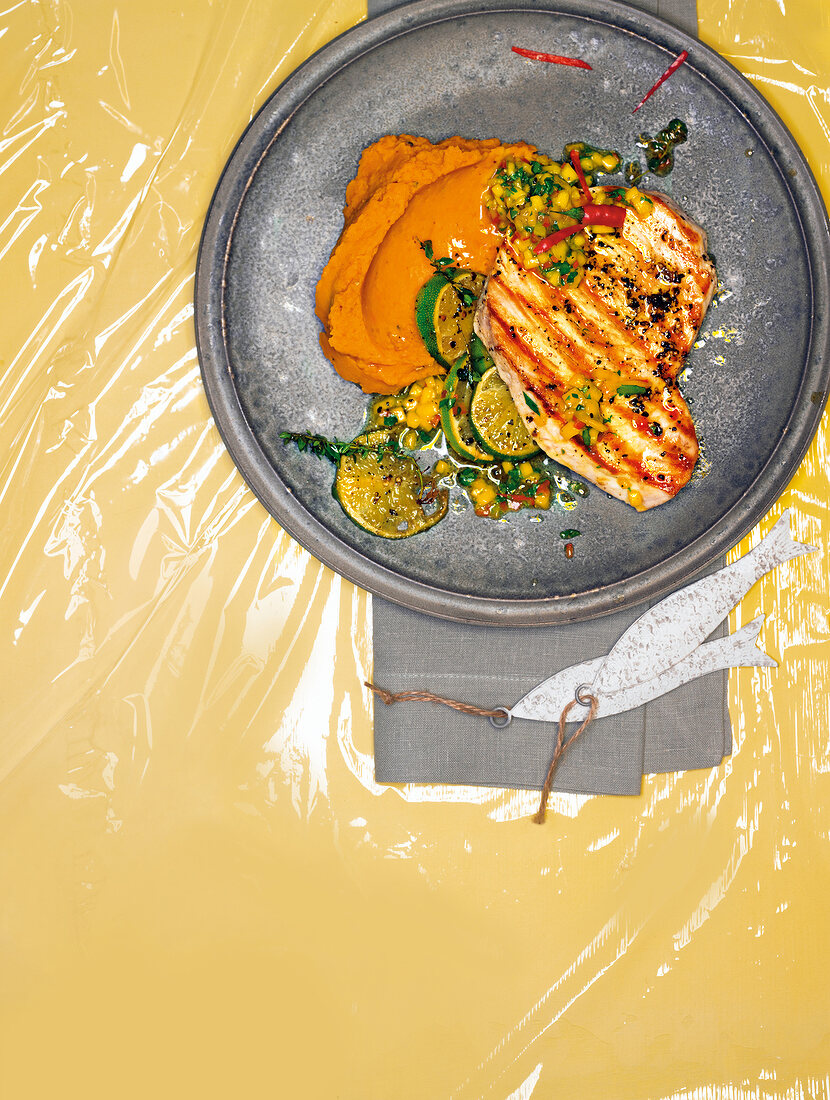 Grilled swordfish with sweet potatoes and mango salsa on plate