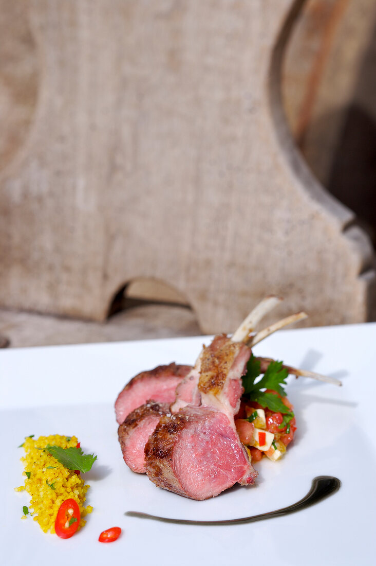 Close-up of grilled lamb with feta, melon salad and couscous on plate