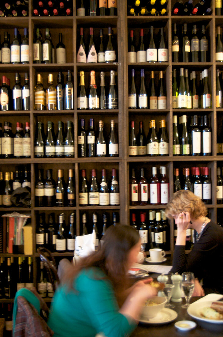 Wine bottles on shelf and people at wine bar in Dublin, Ireland