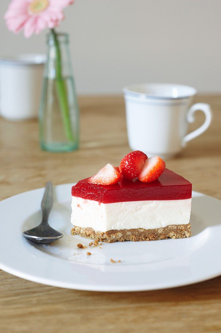 Slice of creamy cheesecake topped with strawberry purée with vodka