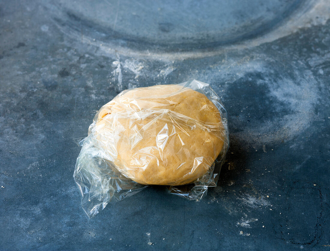 Dough of flour, egg and butter wrapped in plastic foil for preparing cheese cake, step 3