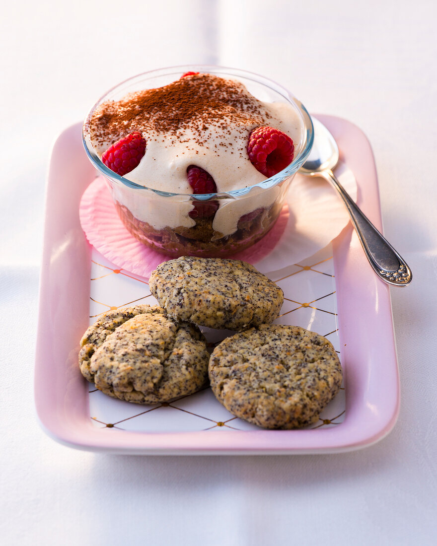 Cocomisu with raspberry in bowl and poppy seed cookies on plate