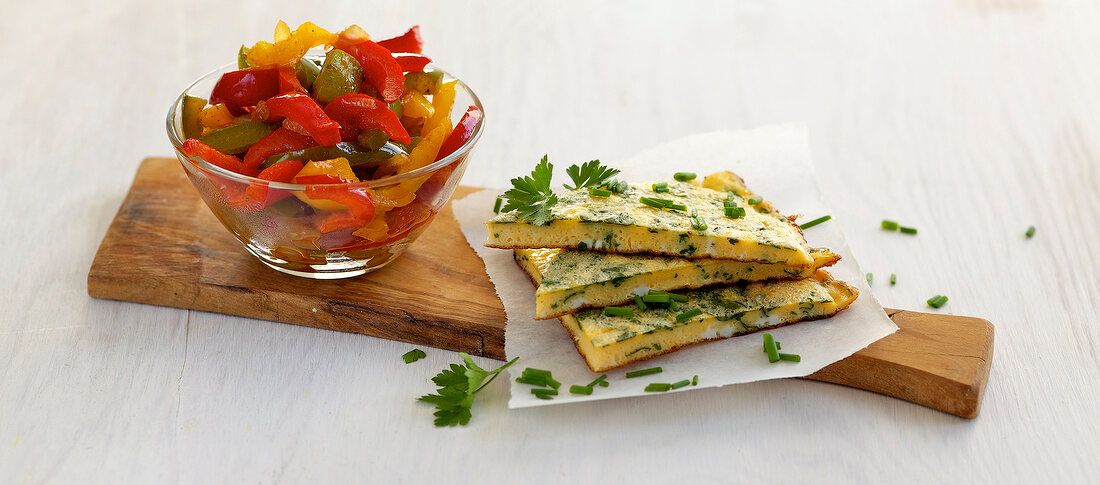 Omelette with herbs and colourful peppers in bowl