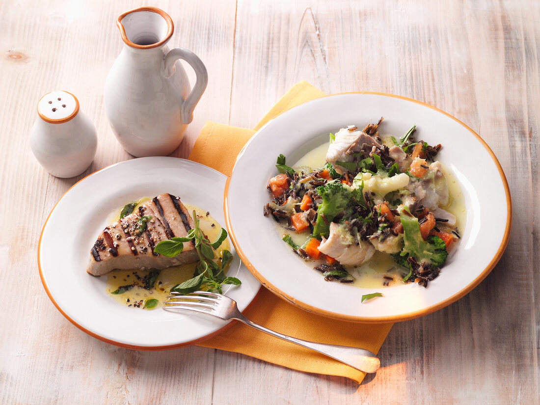 Grilled tuna and fish risotto on plates