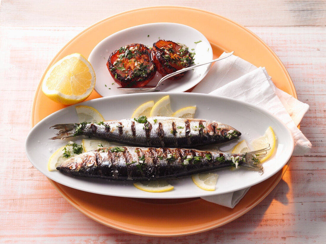 Grilled herring with baked tomatoes in serving dish