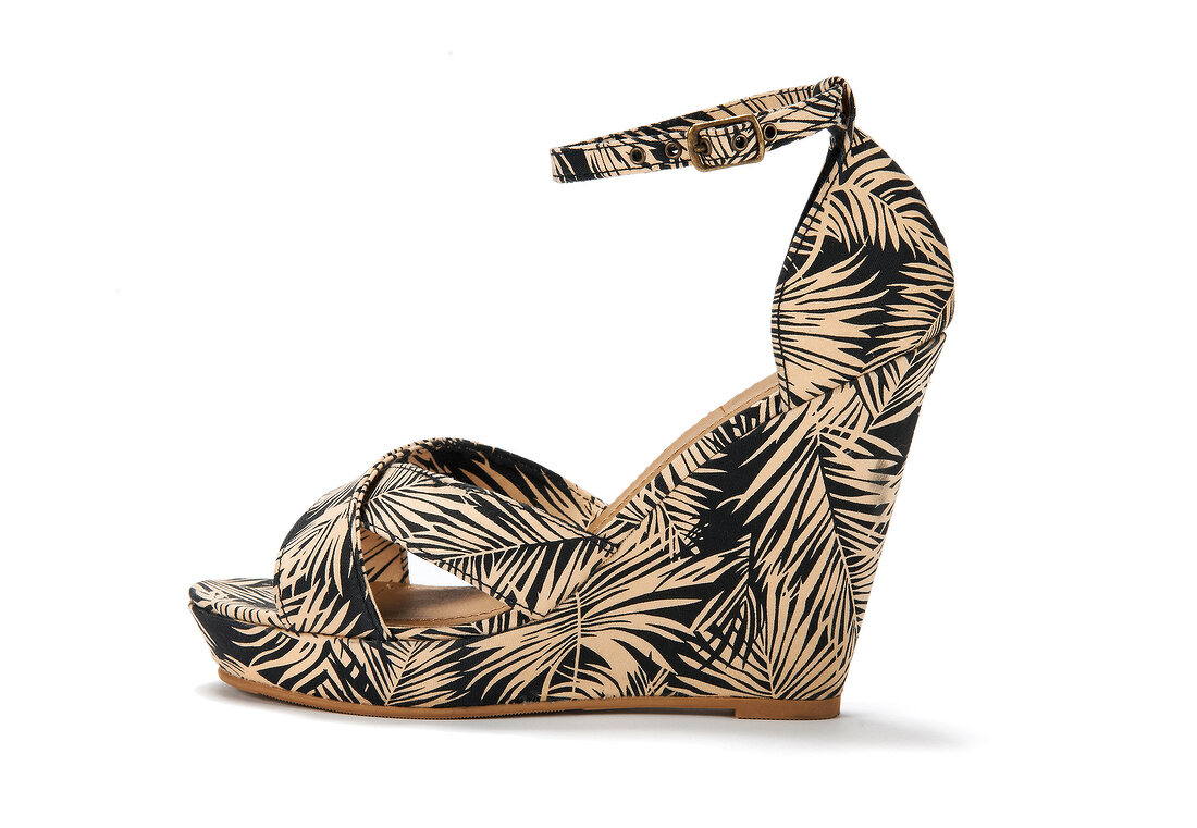 Close-up of African patterned plateaus shoes with wedge heel on white background