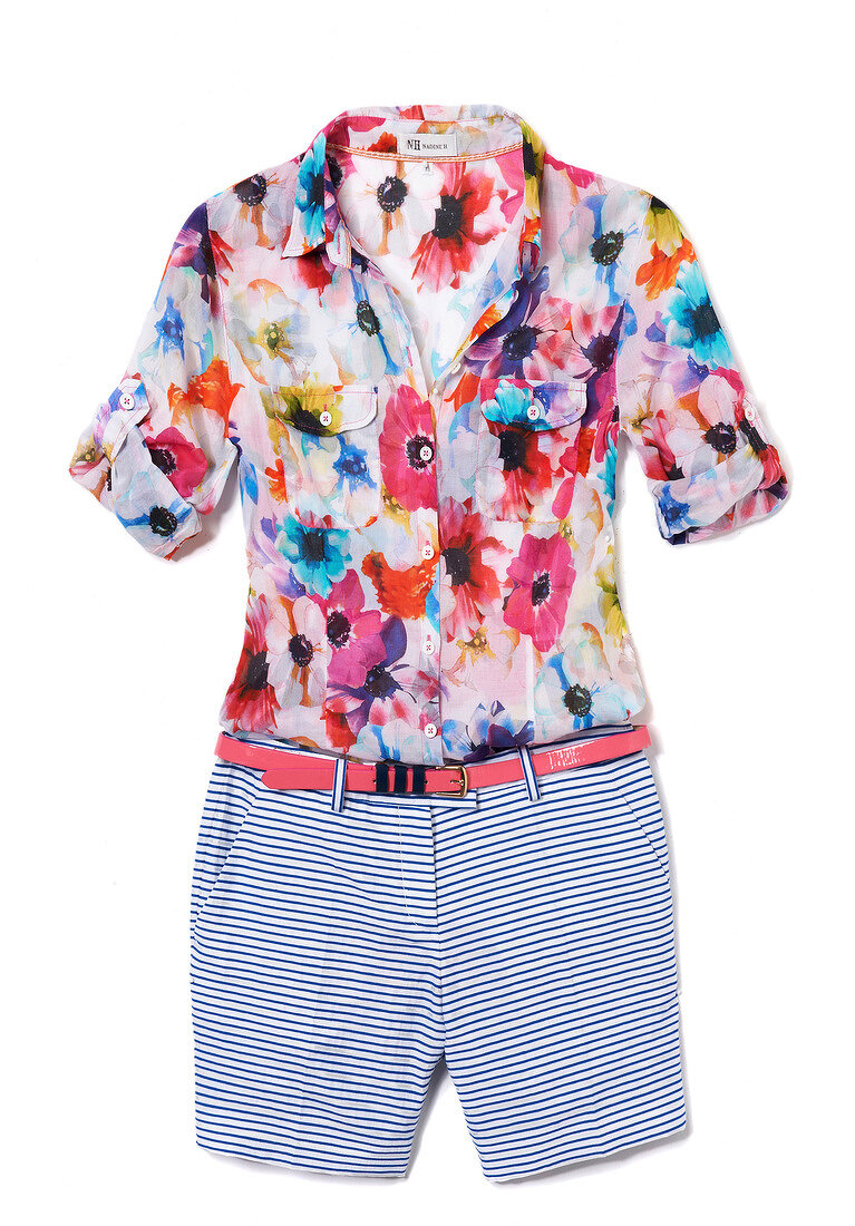 Colourful floral patterned blouse and striped shorts with belts on white background