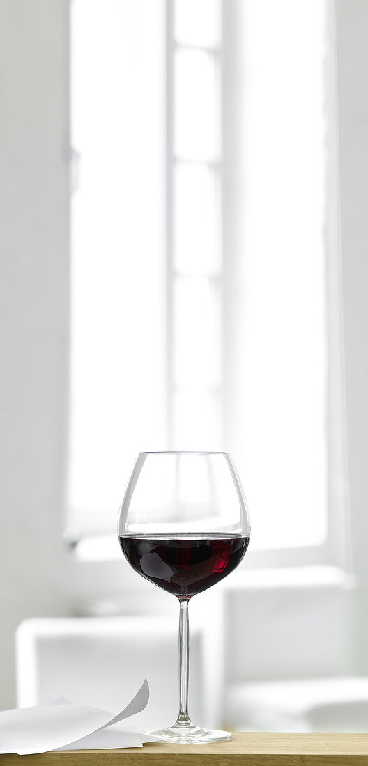 Glass of red wine on wooden table