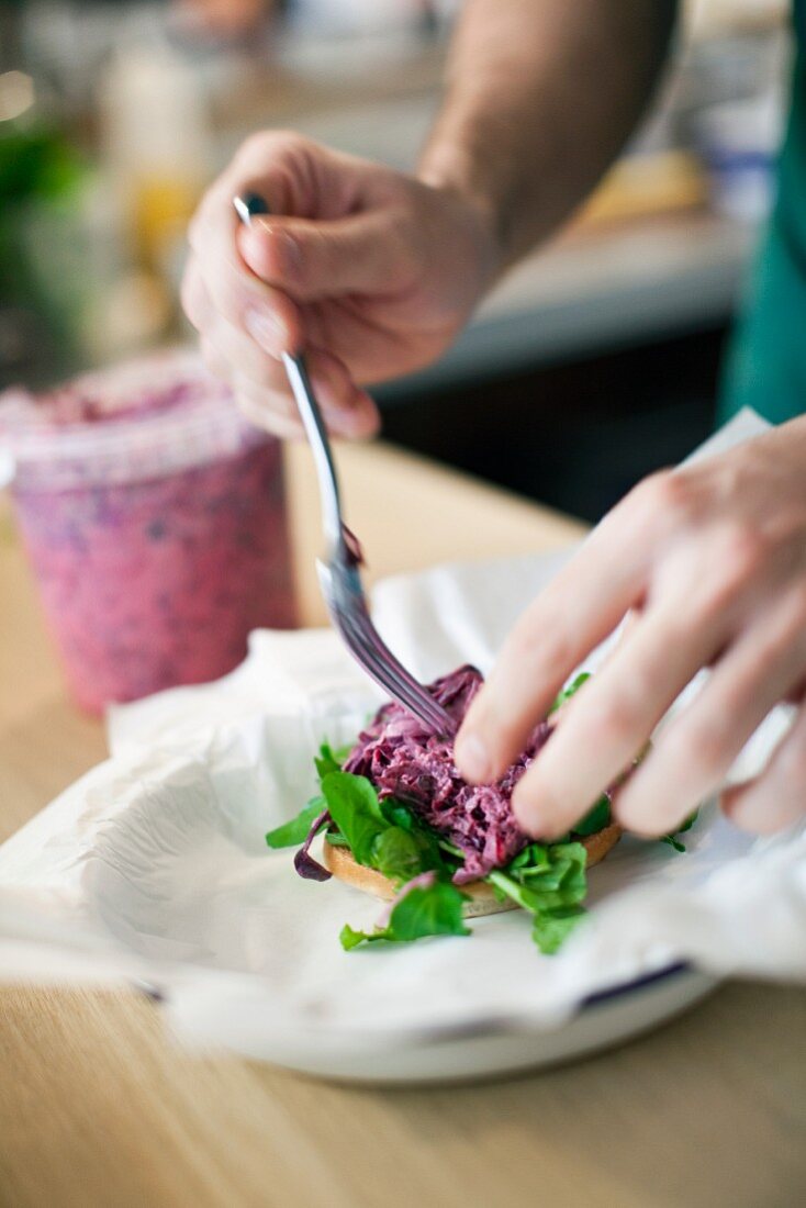 A burger with lettuce and red cabbage being made
