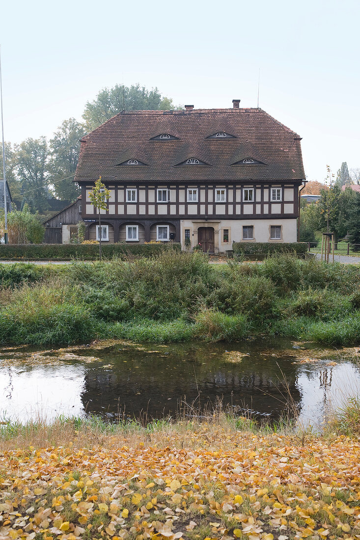 Exterior of timber house beside pond, Saxony, Germany