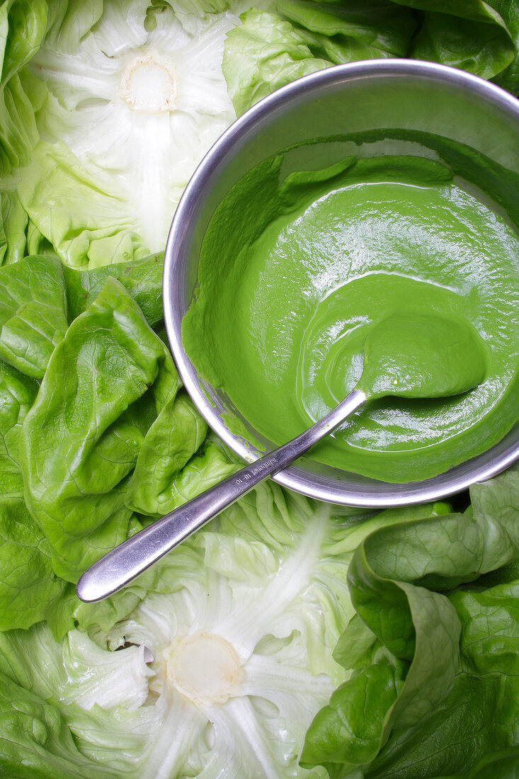 Lettuce soup with spoon in pot