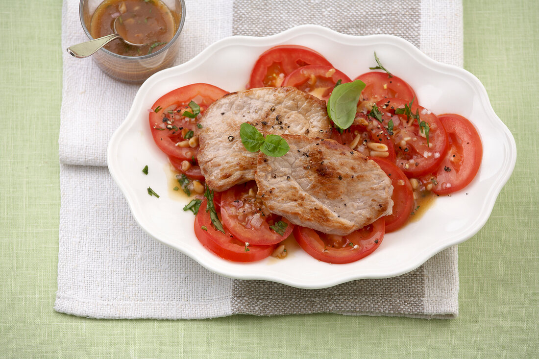 Schnitzel with tomato carpaccio on serving plate