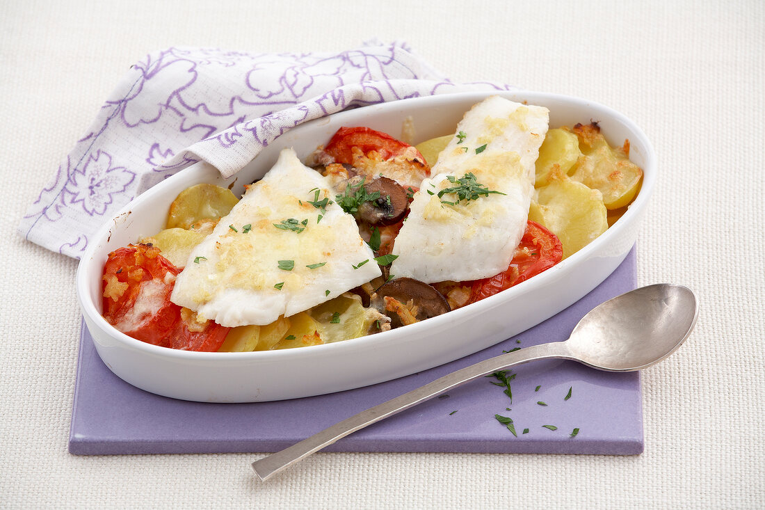 Baked fish with vegetables in serving dish