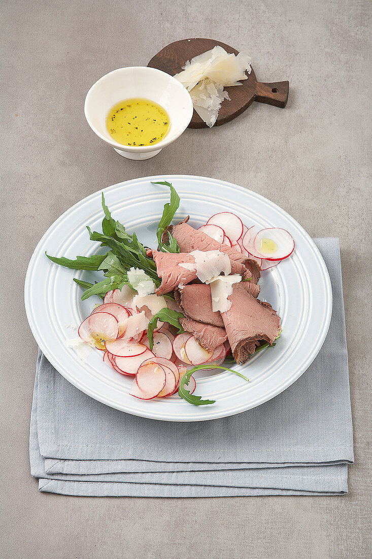 Roasted beef with radish salad on plate