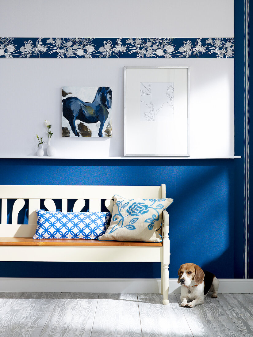 Room with bench, cushion, wall painting and dog