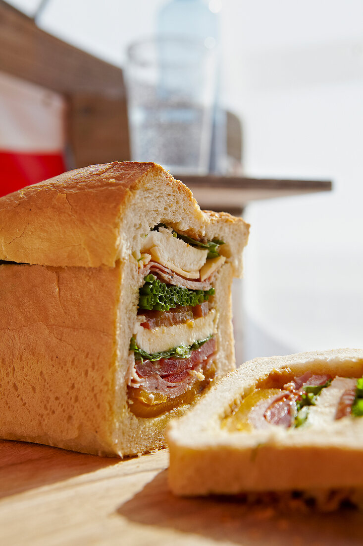 Close-up of sliced bread stuffed with cheese, sausage and salad
